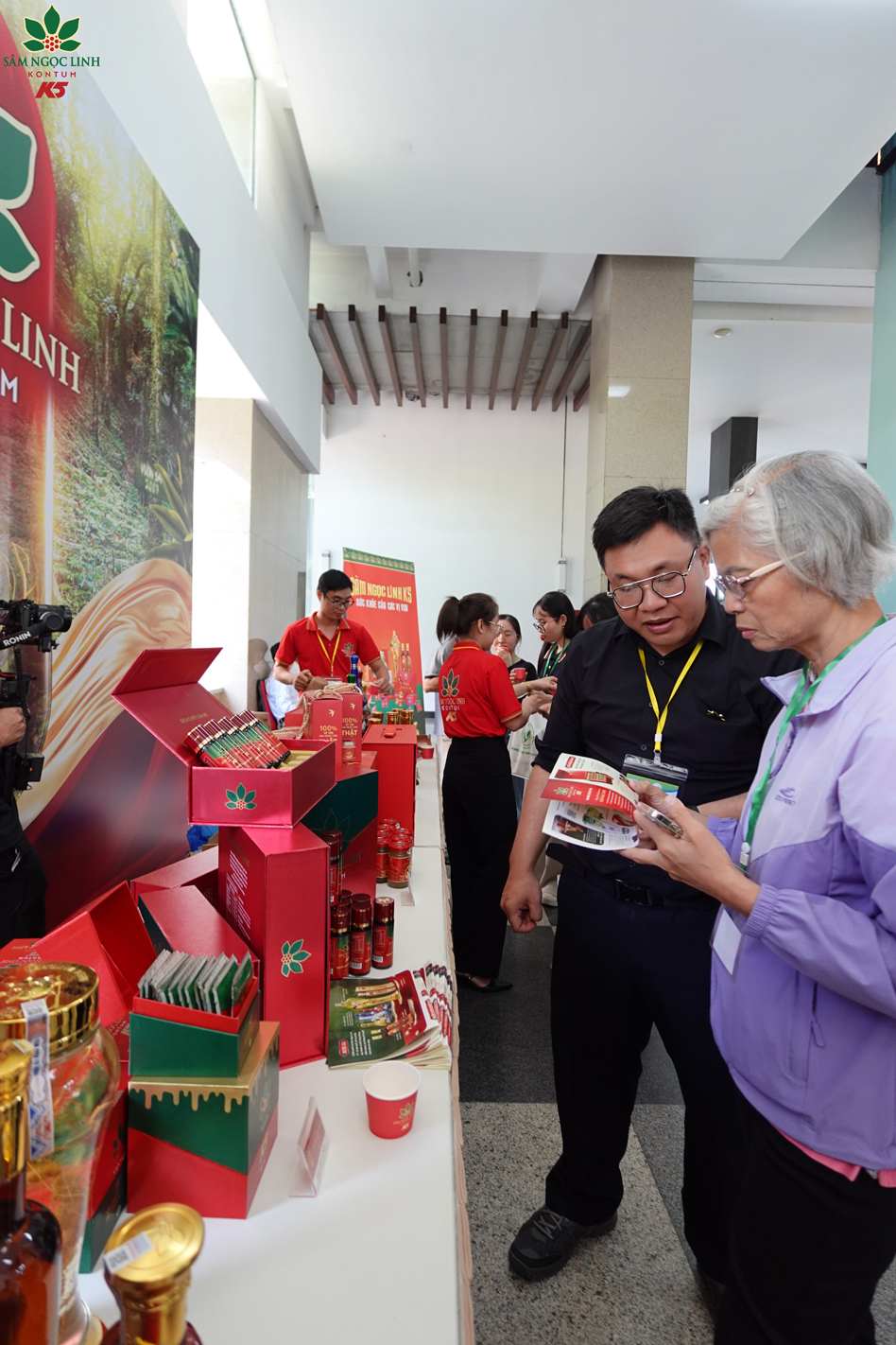 Các đại biểu tham quan và thưởng thức sản phẩm sâm Ngọc Linh tại gian hàng K5.
